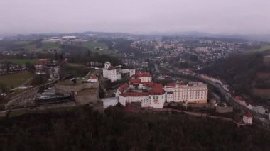Passau 'daki Veste Oberhaus ve Veste Niederhaus' un Drone perspektifi, Tuna-Inn-Ilz kavşağının üzerindeki St. Georgsberg 'de konumlanmıştır. Huysuz kış manzarası ortaçağ kalesini vurguluyor.