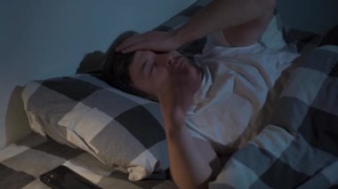 Geceleri uykusuzlukla boğuşan, akıllı telefonuyla saati kontrol eden ve bir bardak su içen bir adam. Çaresizlik içinde tavana bakar ve bir battaniyenin altına saklanır. Endişeden bitkin düşmüştür..