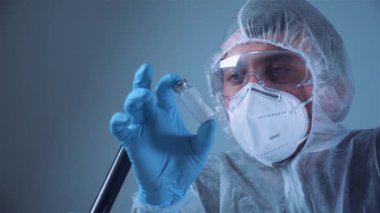 Bilim adamlarının elinde beyaz toz, yasadışı eczane üretimi ve uyuşturucu bulunan ampuller var. Laboratuvar asistanı iğne için cam ampulü inceliyor. Penisilin kuru toz ilacı. Antibiyotik enjeksiyonu.