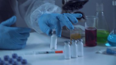 Coronavirus için ilaç geliştirme ve arama. Kimyager enjeksiyon için antibiyotik tozu ampulünü inceliyor. Bakteriyel enfeksiyonu ilaçlarla tedavi etmek. Covid 19 sağlık ve tedavi kavramı.