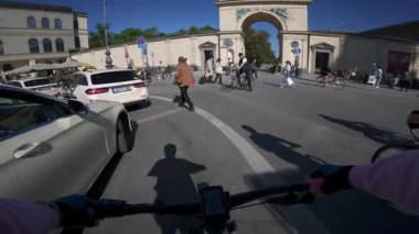 5 Haziran 2025. Münih, Almanya. Almanya, Münih 'in orta kesimindeki Odeonsplatz' da kalabalık bisiklet yolu. Yoğun şehir merkezinde insanlar bisiklet yoluna adım attıkça, bisikletçiler ve yayalar yoğun şehir trafiğinde karışıyor.