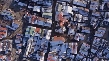 Mittenwald 'ın ana caddesinde güneşli bir kış uçuşu. Barok St Peter ve Paul kilise kuleleri Obermarkt üzerinde. Turistler, karlı dükkanları ve evleri olan tarihi merkezin keyfini çıkarıyorlar.