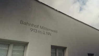 Mittenwald istasyonunun kış manzarası 913 metre irtifada. Karlı Alp arka planına karşı platform. Almanya 'nın Yukarı Bavyera kentindeki tarihi demiryolu mimarisi. Son istasyon, Almanya ile Avusturya arasındaki sınır..