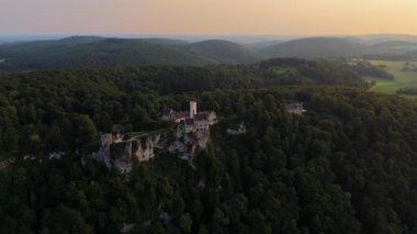 Güney Almanya 'daki Lichtenstein Kalesi' nin panoramik drone görüntüsü. Romantik 19. yüzyıl mimarisi, yemyeşil bir dağ sırtına kurulmuş. Luftaufnahme Schloss Lichtenstein Wuerttemberg.