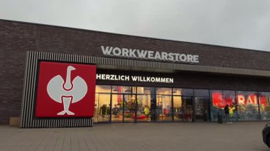 14 Mart 2026. Bergkirchen, Almanya. Engelbert Strauss Giysi Mağazası. Engelbert Strauss atölyesinin modern dış mekanı. Büyük markalı logo ve Herzlich Willkommen girişin üstünde imza var. Ön cephe.