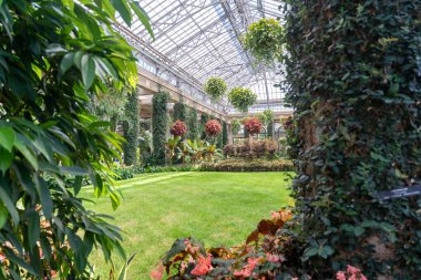 Büyük bir konservatuvarda mükemmel manikürlü çimenliği olan yemyeşil bir kapalı bahçe bulunur. Bu güzel sahne sarmaşık kaplı sütunlar ve asılı sepetlerle süslenmiştir..
