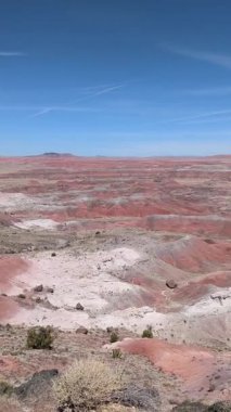 Kachina Point 'ten gelen bu dikey yavaş tepsi Boyalı Çöl' ün uçsuz bucaksız, renkli manzarasını gözler önüne seriyor. Arizona 'daki Petrified Forest Ulusal Parkı' nın çorak toprakları parçalı bulutlu mavi bir gökyüzünün altında kurulmuştur..