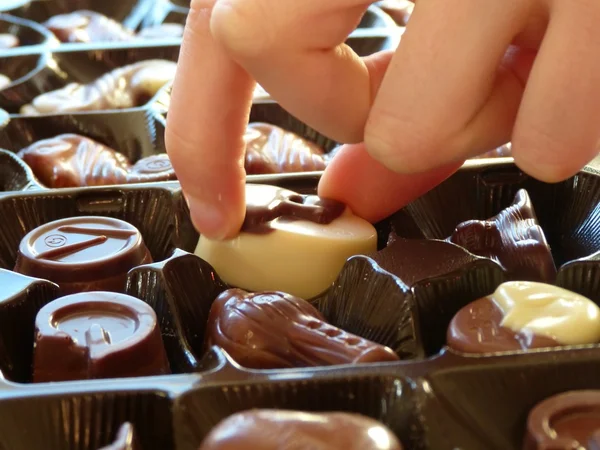 Mujer recogiendo chocolates a mano  . — Foto de Stock