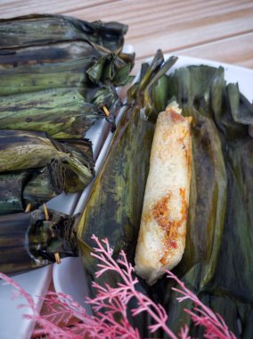 Pulut panggang ya da muz yapraklarına sarılı ızgara glutinous pilav ve baharatlı hindistan cevizi dolgusu. Seçici odak noktaları. Bulanık arkaplan