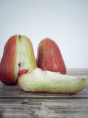 Krájené růžové jablko a celé ovoce, známé také jako jambu air, voskové jablko a chomphu. Selektivní body zaměření.
