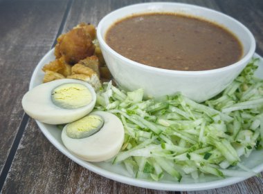 Kızarmış karidesli Hint Rojak, tofu, yumurta, doğranmış salatalık ve fıstık soslu şalgam. Malezya 'da popüler sokak yemekleri. Seçici odak noktaları. Bulanık arkaplan