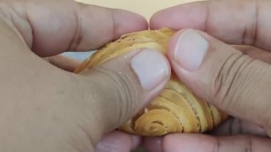 Spiral köri böreğini ya da karipap 'ı ikiye bölerek patateslerin dolmasını sağlıyor. Seçici odak noktaları. Bulanık arkaplan