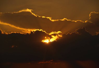 Gün batımı ışıkları bazı bulutların arkasında gizlidir. Seçici odak noktaları. Bulanık arkaplan