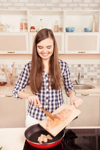 Vrolijke mooi meisje FRJ kip gesneden in de keuken — Stockfoto