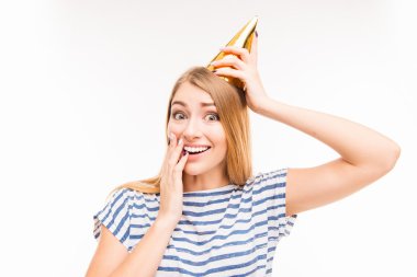 Surprised girl in birthday cap touching her face clipart