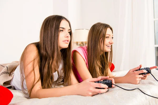 Zijaanzicht foto van twee meisjes spelen video game met joystick — Stockfoto