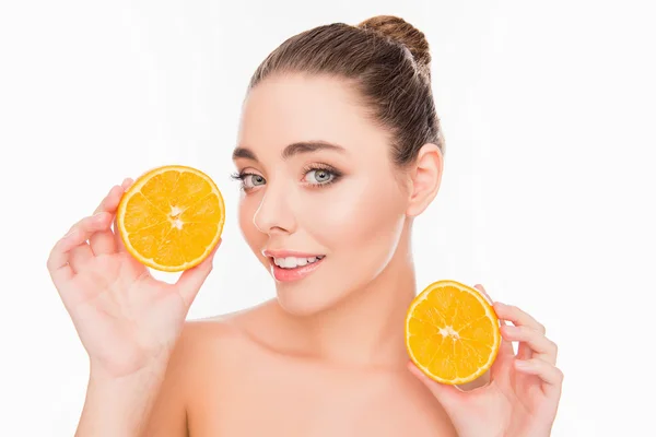 Sonriente joven bonita mujer sosteniendo dos mitades de naranja — Foto de Stock