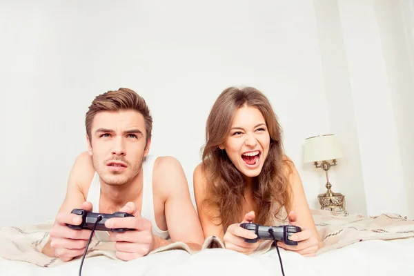 Gelukkige paar in hou van het spelen van videospelletjes met joysticks op de b — Stockfoto