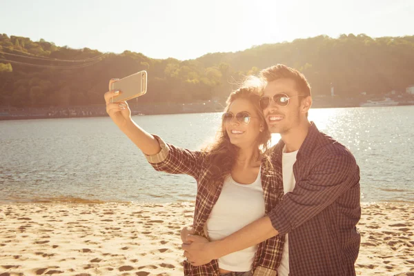Ζευγάρι στην αγάπη κάνοντας selfie φωτογραφία στην παραλία με αγκαλιά — Φωτογραφία Αρχείου