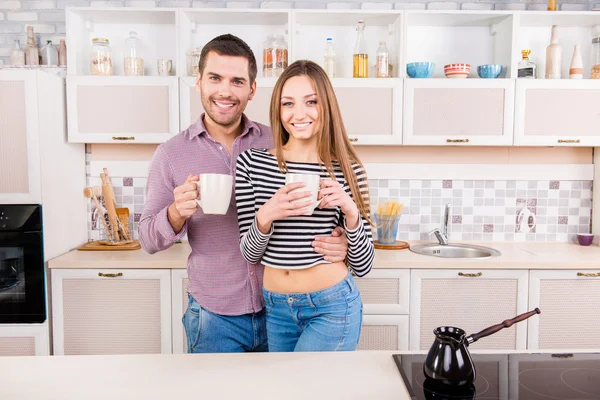 Férfi és nő mosolyogva a konyhában csésze kávét — Stock Fotó