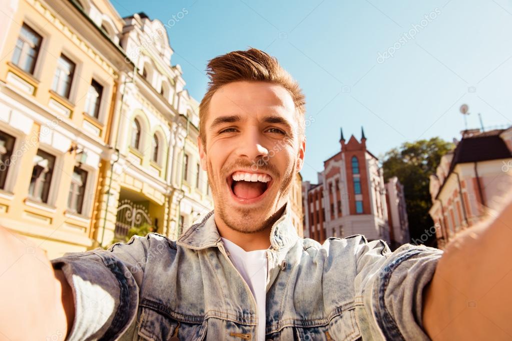 Cheerful happy man making selfie photo on the street Stock Photo by  ©deagreez1 100596582