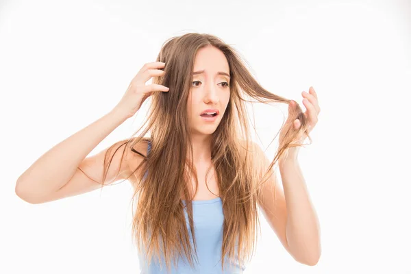 Triste menina bonita olhando para seu cabelo danificado — Fotografia de Stock