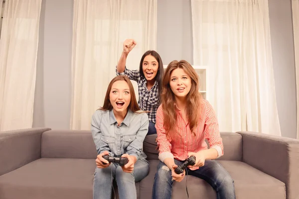 Tre ragazze attraenti felici che giocano ai videogiochi a casa — Foto Stock