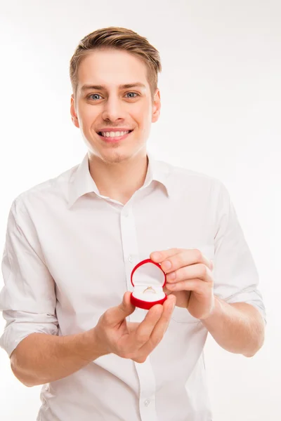 Mignon jeune homme tenant boîte rouge avec anneau de mariage et faisant accessoire — Photo