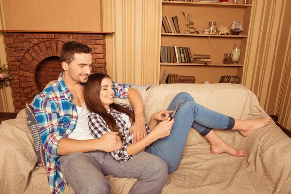 Gärna söta par i kärlek serfing netto i soffan — Stockfoto