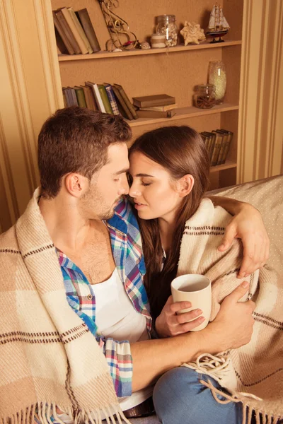 Heureux couple dans l'amour avec plaid et tasse embrasser l 'autre — Photo