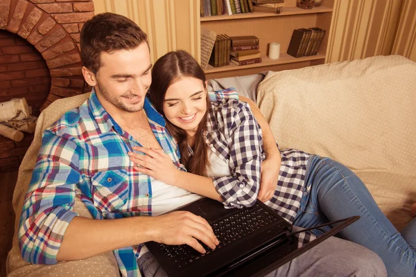 Feliz pareja en el amor con el ordenador portátil abrazar y sentarse en el tan — Foto de Stock