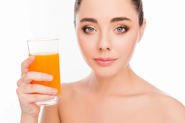Foto de cerca de una mujer sonriente sosteniendo un vaso de jugo de naranja — Foto de Stock