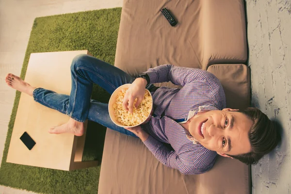 Top vista foto de homem feliz assistindo comédia com pipocas — Fotografia de Stock