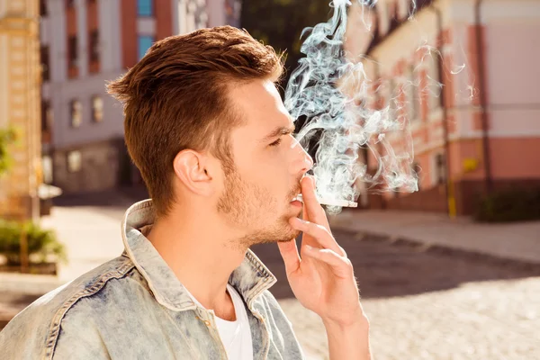 Крупный план, портрет красивого мужчины, курящего сигарету — стоковое фото