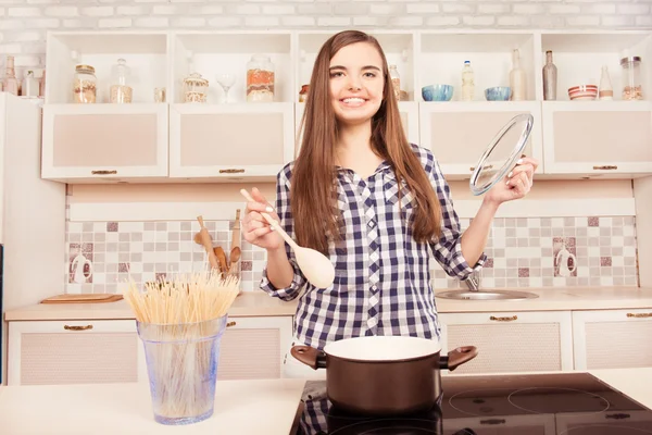 Schattige jonge fornuis kokend spaghetti in de keuken — Stockfoto