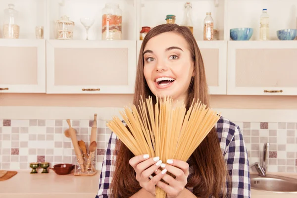 Portret van komische meisje lachen en pasta te houden in de keuken — Stockfoto