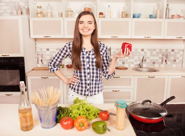 Vrij lachende meisje houdt van rode peper in de keuken — Stockfoto