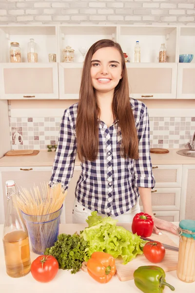 Retrato de dona de casa na cozinha com legumes e espaguete — Fotografia de Stock