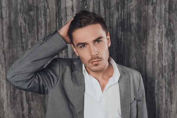 Portrait of handsome businessman in suit touching his hair — Stock Photo, Image