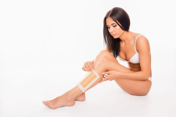 Vacker ung kvinna rakning hennes ben med vax rand — Stockfoto