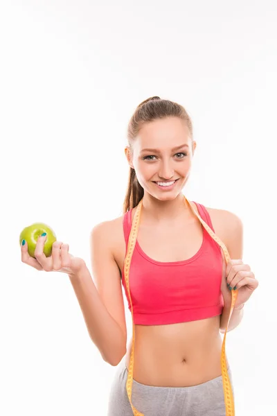 Deportiva chica con cinta métrica y manzana verde — Foto de Stock