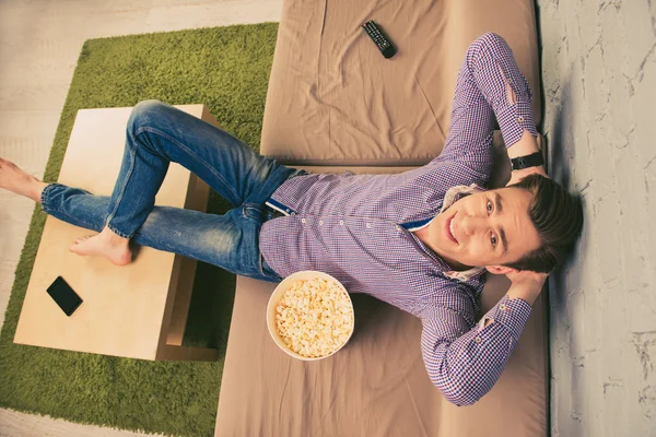 Top vista foto de homem atraente relaxante em casa com pipocas — Fotografia de Stock