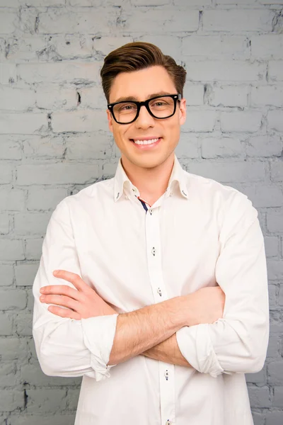 Attractive young man in glasses posing with crossed hands — Stock Photo, Image