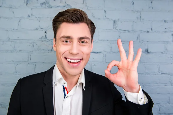 Happy smiling man in black jacket gesturing "OK" — Stock Photo, Image