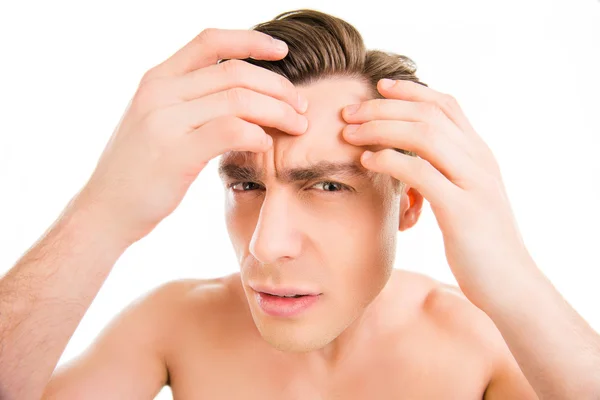 Close up photo of young man looking for acnes on his face — Stock Photo, Image