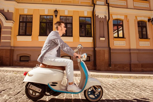 バイクに乗ってメガネでハンサムな幸せな男の側面図 — ストック写真