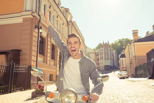 Bonito homem feliz montando uma moto pegando mão — Fotografia de Stock