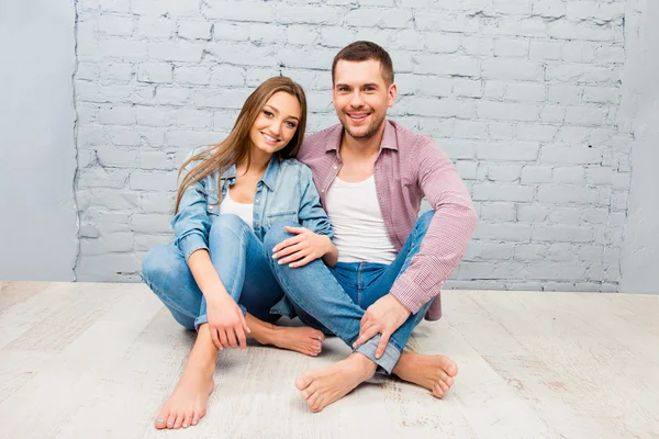 Feliz bonito homem e mulher sentados descalços no chão — Fotografia de Stock
