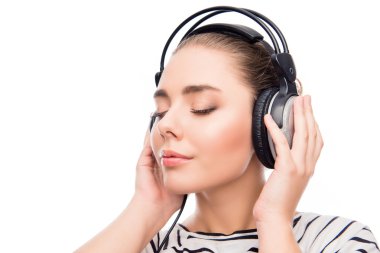 Relaxed calm girl listening music in headphones with closed eyes clipart