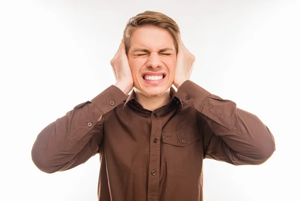 Jovem irritado tapando ouvidos com as mãos — Fotografia de Stock